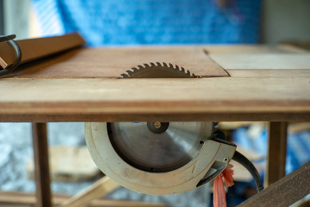 Close-up van de metalen schotel van elektrische zaagmachine in de tafel in de werkplaats - Foto, afbeelding