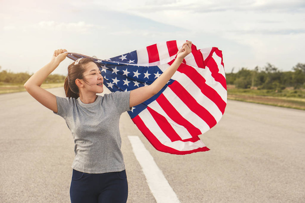 Mujer asiática feliz con bandera americana EE.UU. celebrar 4 de julio
 - Foto, imagen