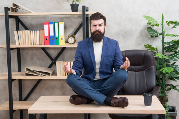 Prevent professional burnout. Way to relax. Meditation yoga. Self care. Psychological help. Relaxation techniques. Mental wellbeing and relax. Man bearded manager formal suit sit lotus pose relaxing - Foto, afbeelding