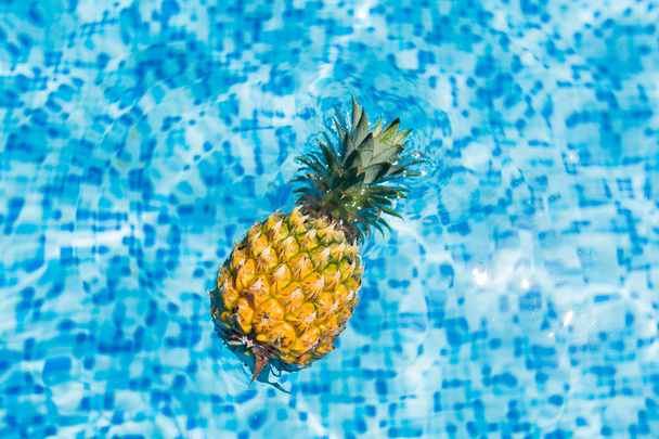 Conceito de férias de verão, abacaxi fresco nada na piscina do hotel. Férias, alimentação saudável, conceito tropical
 - Foto, Imagem