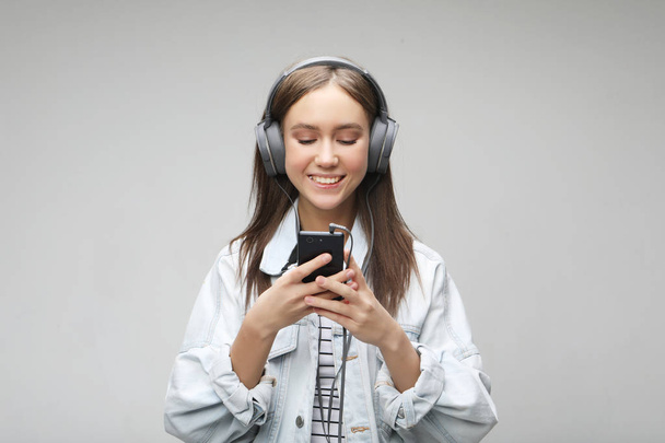 Gyönyörű fiatal nő, zenehallgatás fejhallgató smartphone  - Fotó, kép