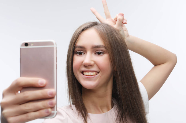 happy smiling young woman wearing taking selfie with smartphone - Foto, Bild