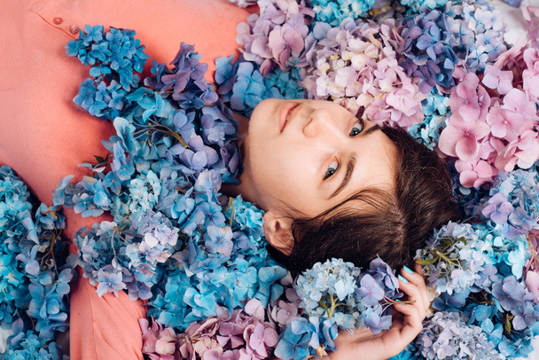 Spring woman with hydrangea flowers. Makeup cosmetics and skincare. Summer beauty. Fashion portrait of woman. Healthy hair and skin. girl with summer makeup. Look over there - 写真・画像