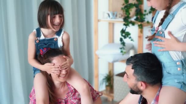 Daughters sits on shoulders of their parents and family has fun, slow motion - Video