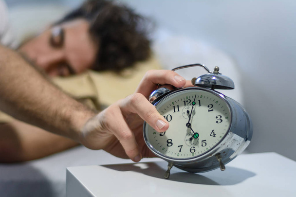 Frustrated young man woken-up by his alarm clock - Фото, зображення