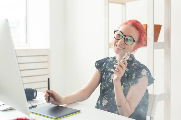 Créatif, graphiste, concept de personnes - jeune femme créative fumant une vape tout en travaillant dans une tablette graphique
 - Photo, image