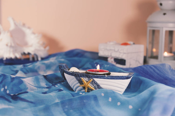 Malý lodní držák svíčky, krabice, Lucerna a lasturu leží na modrém materiálu - Fotografie, Obrázek