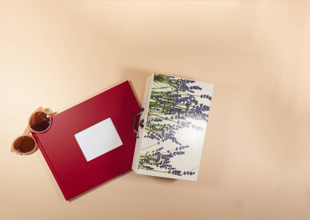 Egy piros boríték, egy fehér doboz, és napszemüveg fektetése egy rózsaszín felületre - Fotó, kép