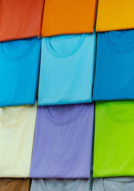 Крупный план красочных футболок на вешалках
 - Фото, изображение