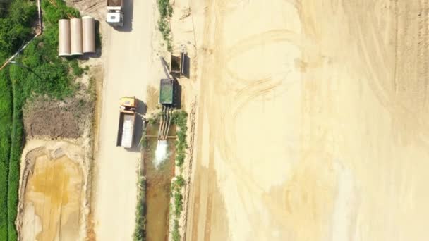 Dumper caminhão com areia está indo, passando sobre o lado da construção da estrada. Vista aérea
 - Filmagem, Vídeo
