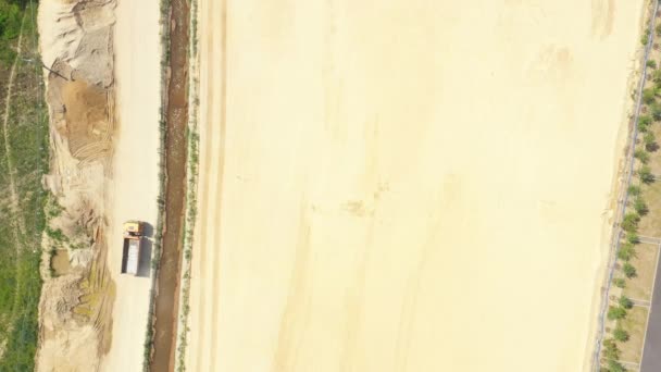 Camión volquete con arena va, pasando por el lado de la construcción de carreteras. Vista aérea
 - Metraje, vídeo