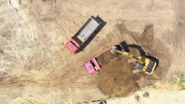 Blick von oben auf Bagger, der Sand in Kipper gießt. Bergbau - Filmmaterial, Video