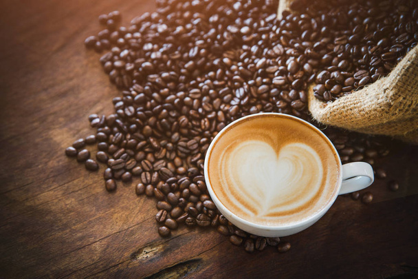 Kaffee-Latte mit Kaffeebohnen auf dunklem Hintergrund, Draufsicht - Foto, Bild