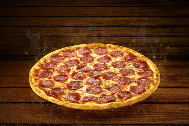 Pizzaa puupöydällä. Flying kuuma pizza pepperoni lähikuva mozzarella juustoa ja höyryä savu
  - Valokuva, kuva