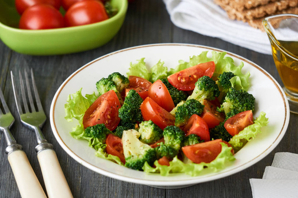 Salad with broccoli and cherry tomatoes in a white bowl                                - Photo, Image