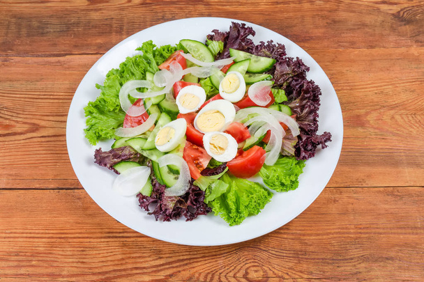 Groente salade met gekookte kwarteleitjes op de witte schaal  - Foto, afbeelding