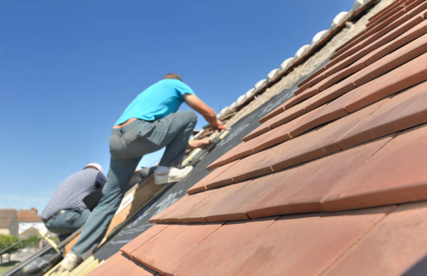 στεγών σε στέγη που εργάζεται για την ανακαίνιση ενός σπιτιού  - Φωτογραφία, εικόνα