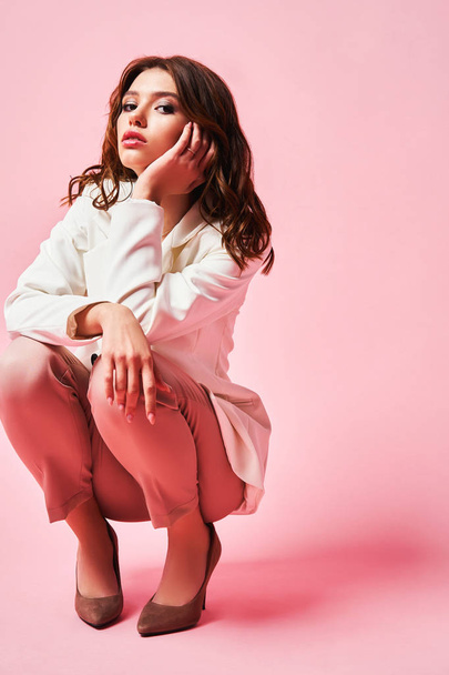 Teen girl, open hand. Professional makeup. Beauty teenage model in the studio. Pink and white background - Foto, Bild