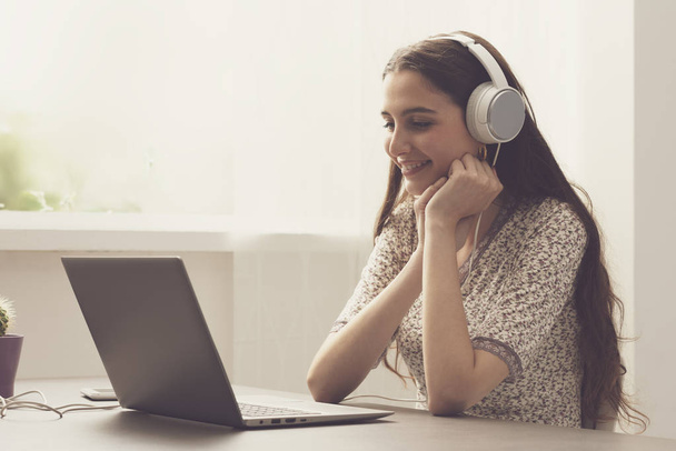 Cute woman watching movies online with her laptop - Fotó, kép