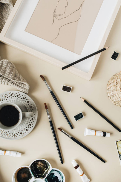 Suluboya sanatçı ev ofis masası çalışma alanı bej arka plan üzerinde. Kahve fincanı, boya fırçası, boyama, suluboya. Düz yatıyordu, üst tenli blog, sosyal medya, web sitesi konsepti. - Fotoğraf, Görsel