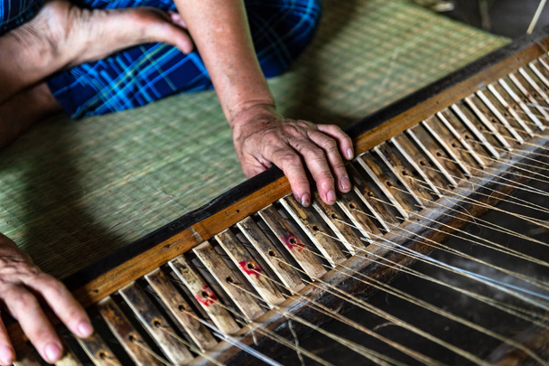 Zbliżenie na rękach starej kobiety tkania Mata Turzyca w Ben Tre, Region Delty Mekongu, Wietnam. - Zdjęcie, obraz