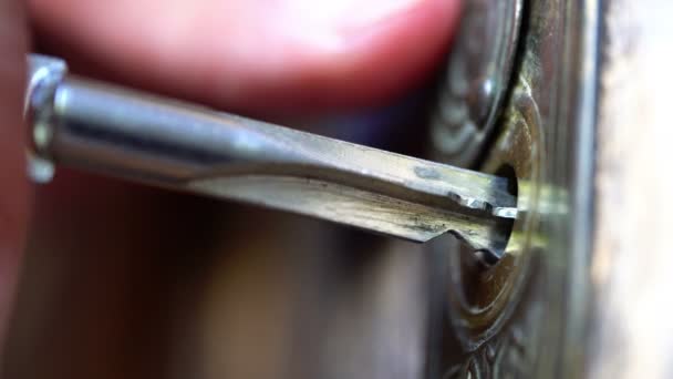 Chave inserida em um buraco de chave na porta de madeira e girada à mão
 - Filmagem, Vídeo