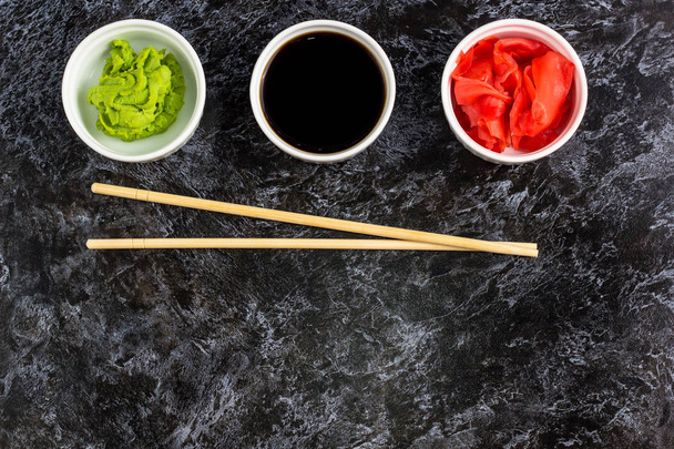 Set for sushi soy sauce ginger wasabi with chopstick on stone background - Photo, Image