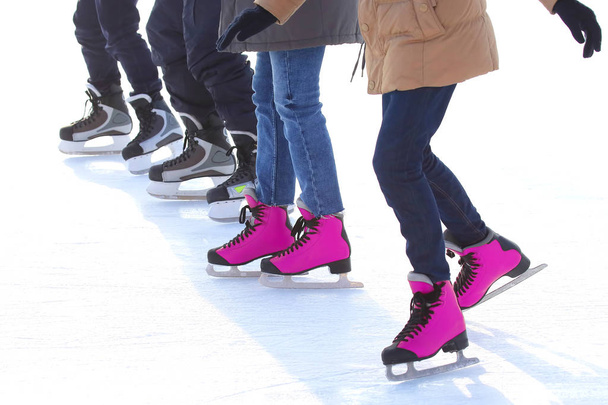 feet of different people skating on the ice rink - 写真・画像