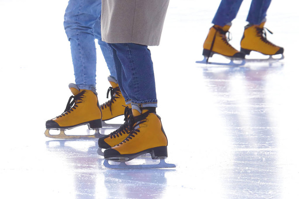pés de pessoas diferentes patinando na pista de gelo
 - Foto, Imagem