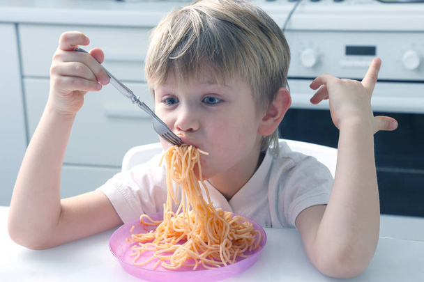 パスタを食べる小さな子供。子供の伝統的な食べ物 - 写真・画像