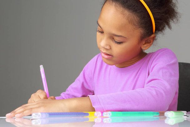 la chica dibuja con lápices de colores en el pape
 - Foto, Imagen