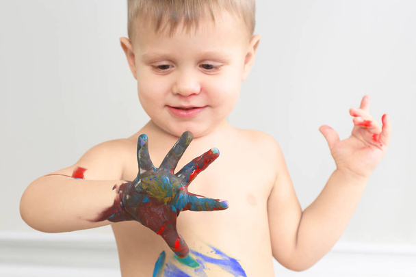 το παιδί χρωματίζει με το χρώμα το χέρι σας - Φωτογραφία, εικόνα