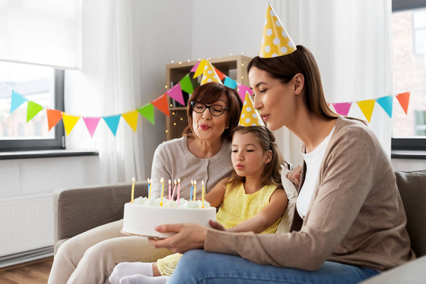 mother, daughter, grandmother with birthday cake - 写真・画像