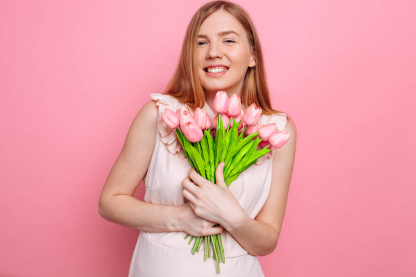Happy girl in summer dress holding a bouquet of flowers in hand - Foto, afbeelding