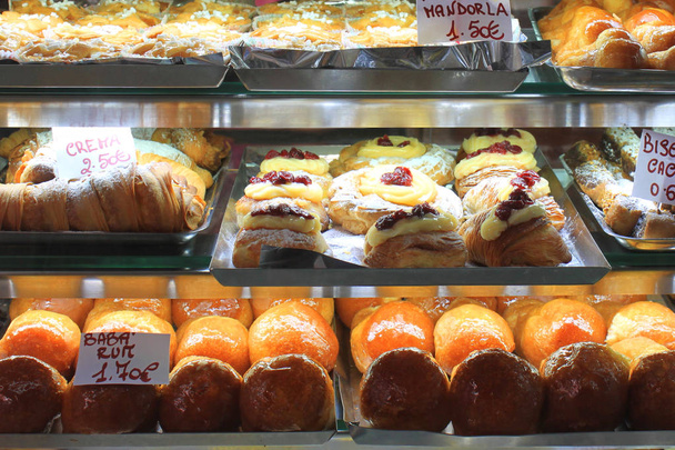 Varios dulces de postre y pasteles en el escaparate o en la cafetería de cerca
 - Foto, Imagen