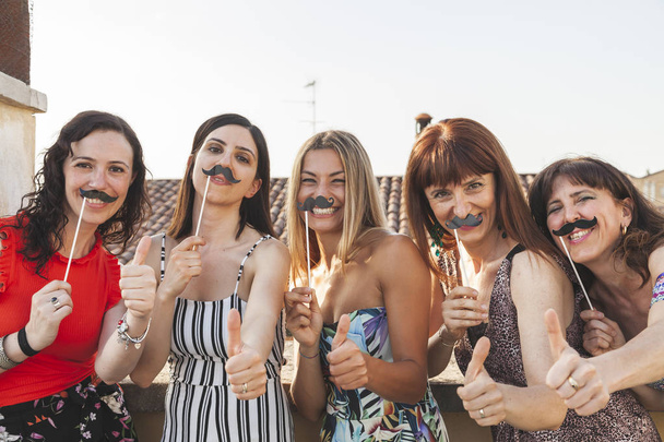 group of female friends having fun with party accessories on the - Foto, immagini