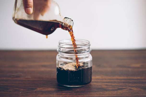Cold Brew koffie zwarte koffie in een glas, melk toevoegen - Foto, afbeelding