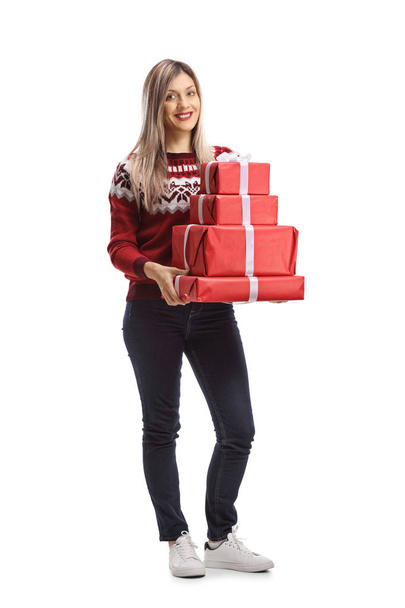 Full length portrait of a pretty young woman holding a pile of presents isolated on white background - Foto, afbeelding
