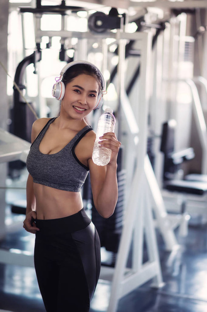 attraente donna tenere bottiglia d'acqua in palestra
 - Foto, immagini