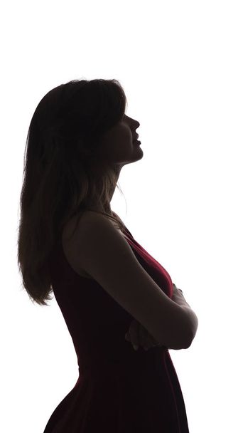 profile silhouette of a young calm woman in dress looking, figure of beautiful girl on a white isolated background - Foto, imagen