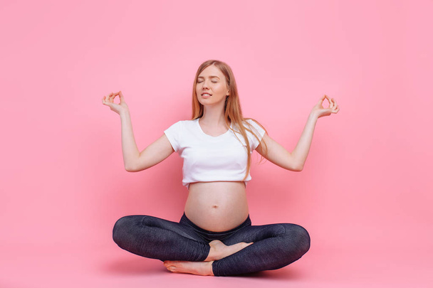 Young beautiful pregnant woman does yoga exercise - Foto, Imagen