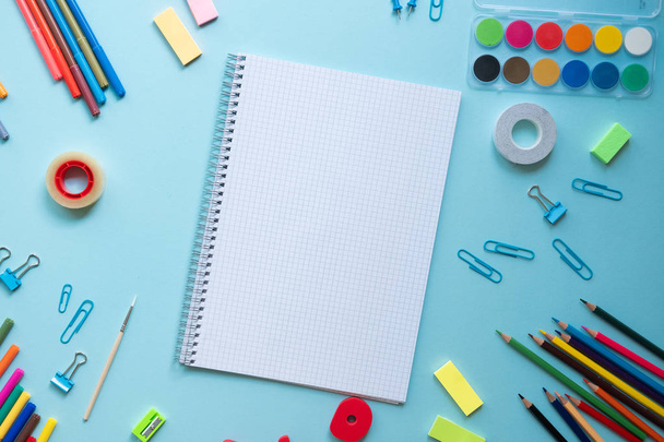 Colorful school supplies over a blue background with place for your text - Photo, Image