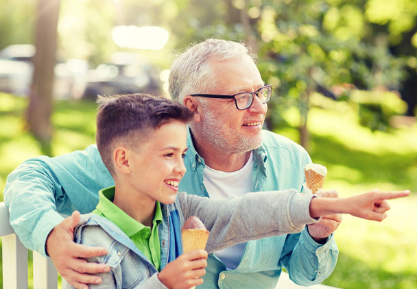hombre viejo y niño comiendo helado en el parque de verano
 - Foto, imagen