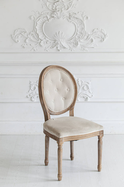 Living room in antique style. Vintage chair against the wall with a bas-relief of plaster stucco. Selective focus. - Φωτογραφία, εικόνα