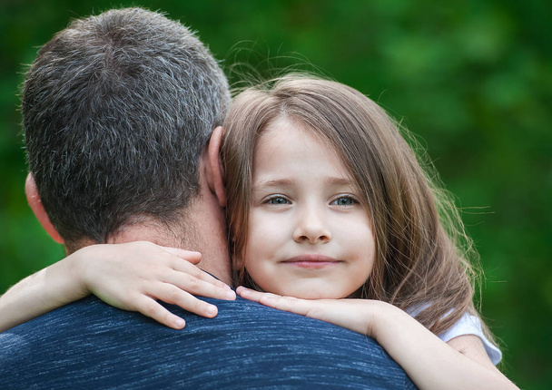 Portrait of cute little girl held in father's arms. Happy loving family. Father and his daughter child girl playing hugging. Cute baby and daddy. Concept of Father day. Family holiday and togetherness - Fotoğraf, Görsel