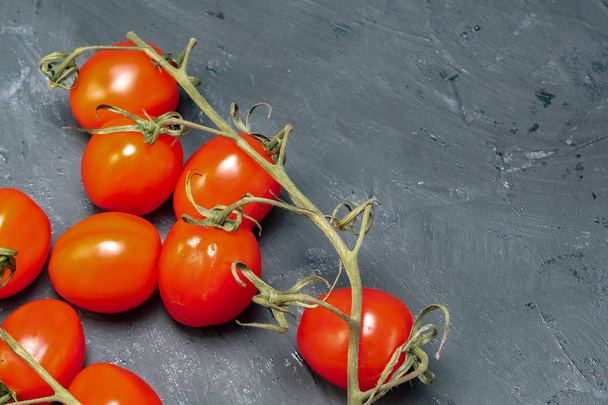 branch of tomato cherry on a black background - Foto, afbeelding