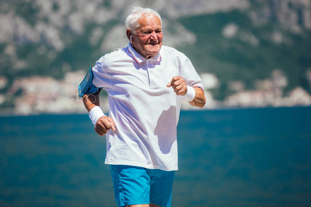 щасливий старший чоловік робить ранкову вправу на пляжі
 - Фото, зображення