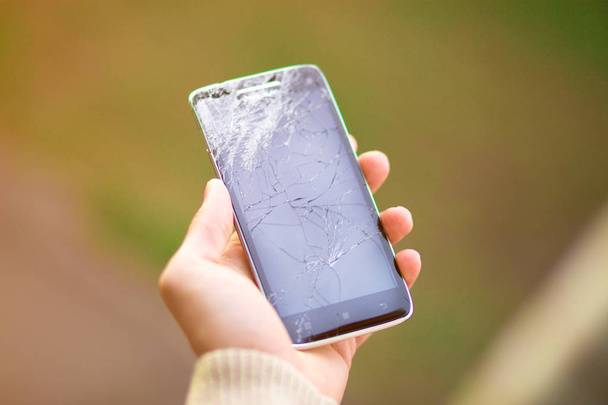 young man hold broken smartphone screen. Broken phone in hand - Photo, Image