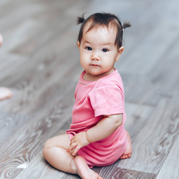 Szép aranyos baba Kazah egy éves lány sittimg a padlón otthon - Fotó, kép