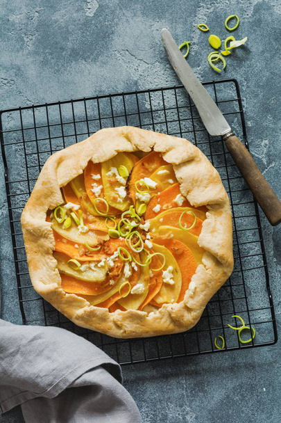 Pumpkin, potato, feta cheese and leek galette pie plate on gray concrete table background. Top view.l - Photo, Image